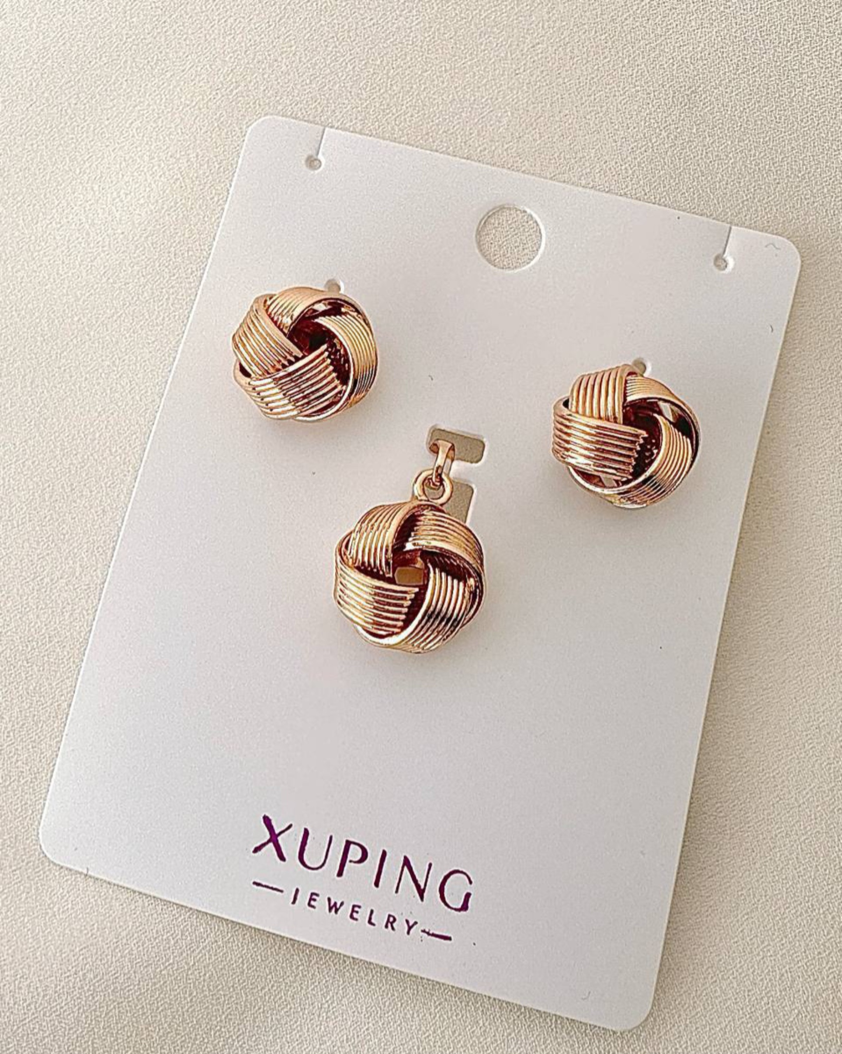 نیم ست بدلیجات برند ژوپینگ طرح گره رزگلد شامل گوشواره میخی و آویز