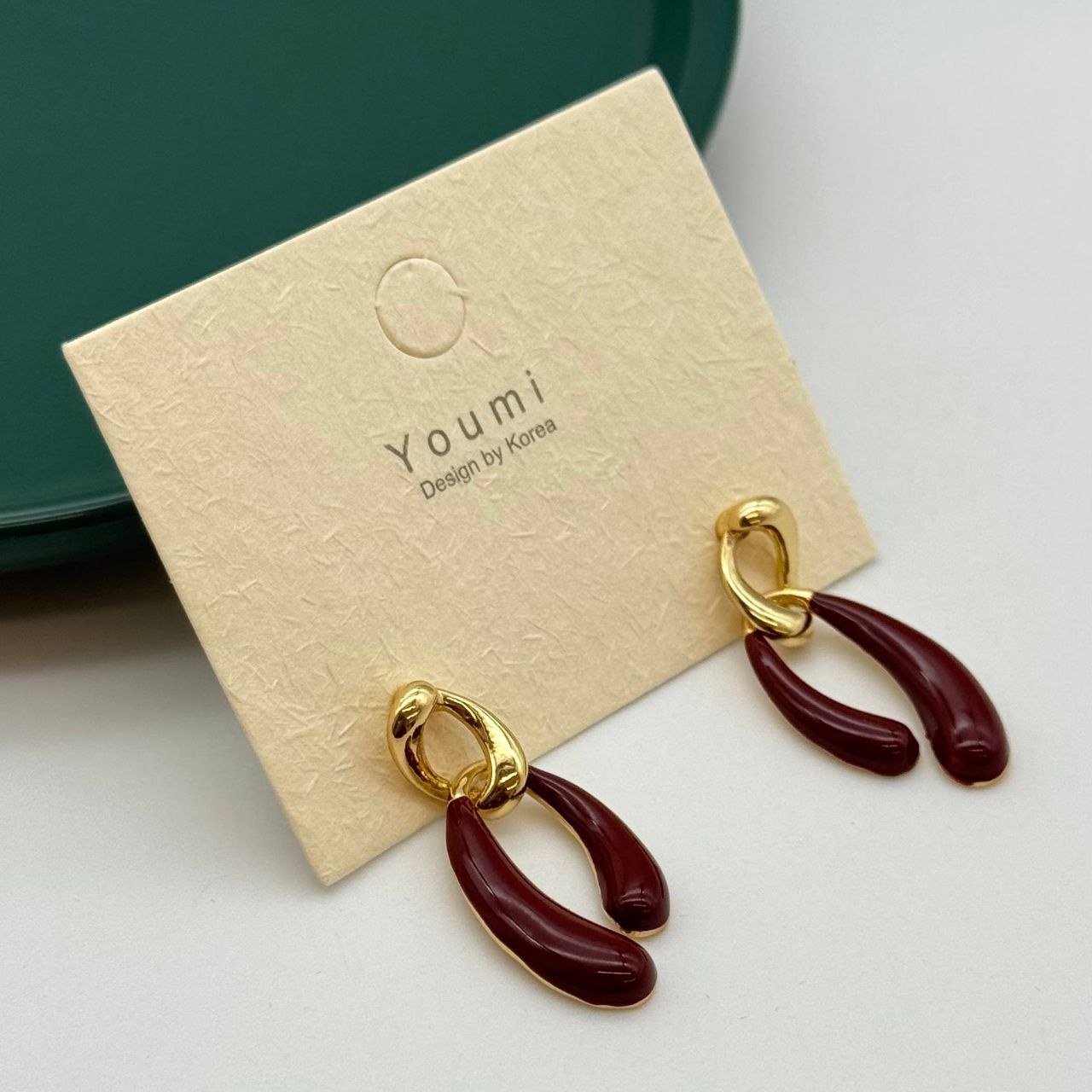 گوشوارههای مینیمال برند Youmi با طراحی کرهای در دو رنگ مشکی و زرشکی