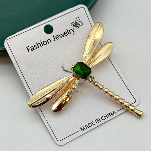 گل سینه طلایی طرح سنجاقک با نگین سبز مستطیلی و بدنهی شیاردار