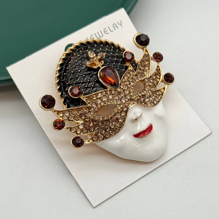 گل سینه مجلسی طرح چهره با ماسک طلایی نگیندار و سنگهای زرشکی