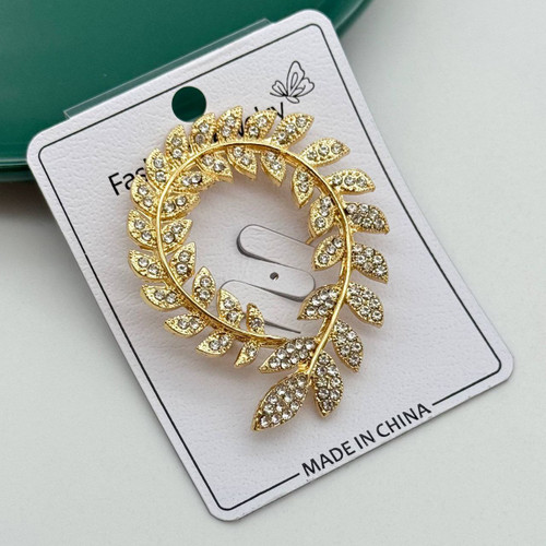 گل سینه طلایی طرح دایرهای شاخه زیتون با نگینهای کریستالی درخشان