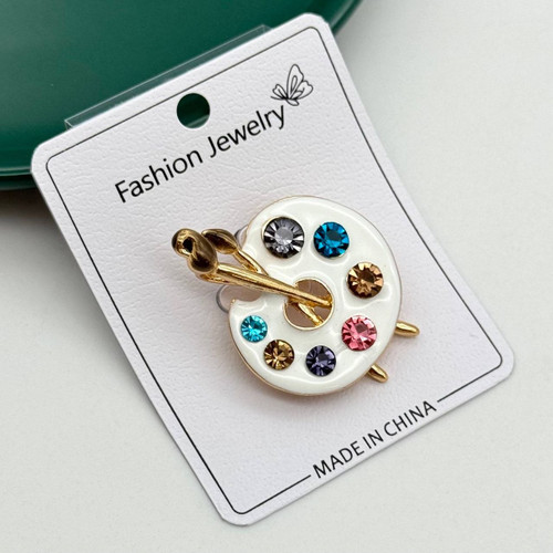 گل سینه فانتزی طرح پالت نقاشی سفید با نگینهای رنگی و قلممو طلایی