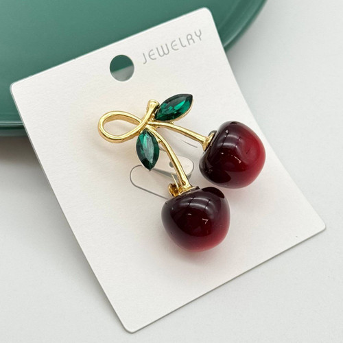 گل سینه طرح دو گیلاس براق زرشکی با برگهای سبز کریستالی و شاخه طلایی