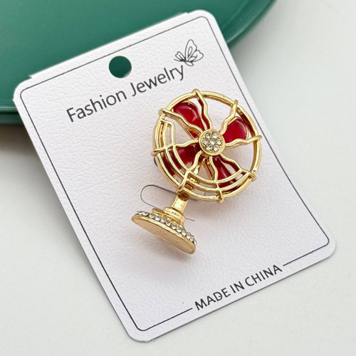 گل سینه مجلسی طرح پنکه نوستالژیک طلایی با پرههای قرمز و نگینکاری ظریف