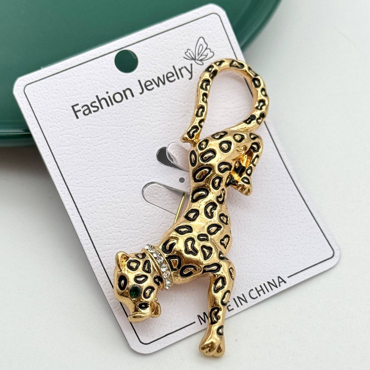 گل سینه طلایی طرح پلنگ با خالهای مشکی و چشم سبز زمردی