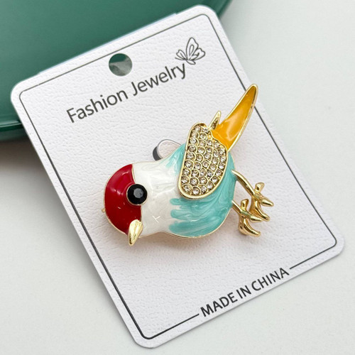 گل سینه فانتزی طرح پرنده با رنگبندی قرمز و آبی و بال نگیندار