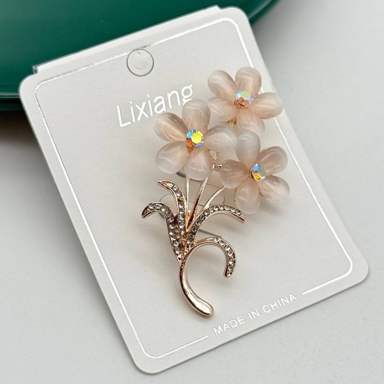 گل سینه طلایی طرح دسته گل با سنگهای صورتی ملایم و نگینهای درخشان