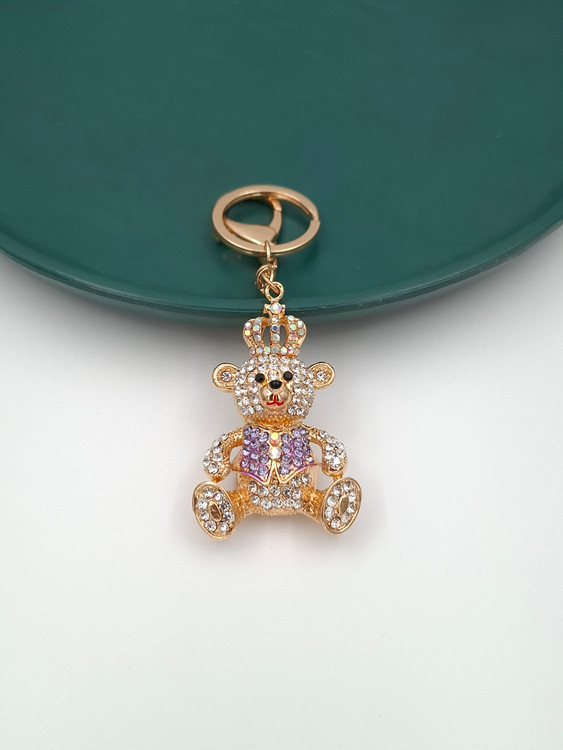 جاکلیدی طلایی طرح خرس تدی نگیندار با تاج پادشاهی و نگینهای بنفش.