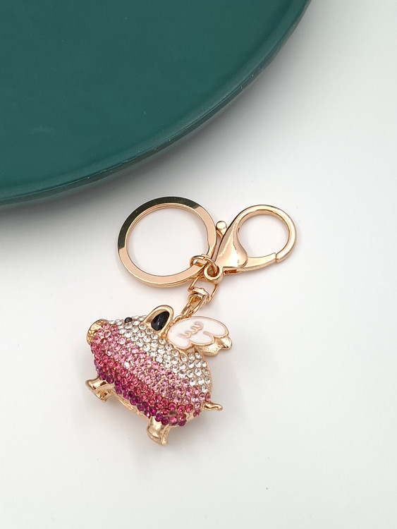 جاکلیدی طرح خوک نگیندار صورتی و سفید با بالهای کوچک و گیره طلایی