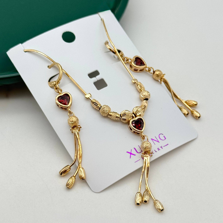 نیم ست بدلیجات ژوپینگ طلایی با نگین قرمز قلبی و آویزهای شرابهای