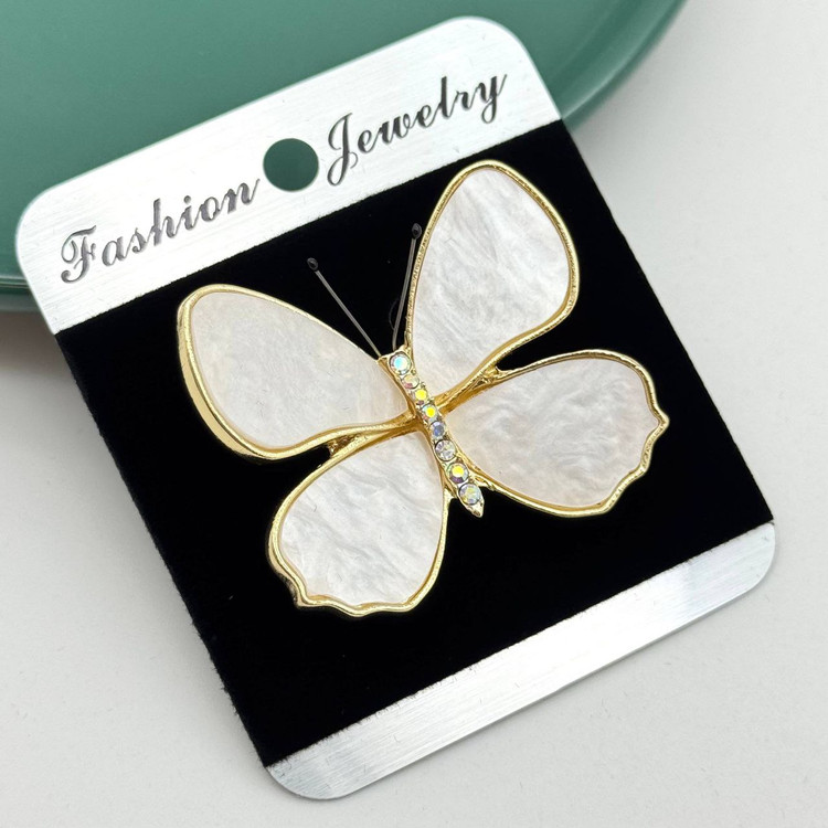 گل سینه طلایی طرح پروانه با بالهای صدفی سفید و بدن نگینکاری شده