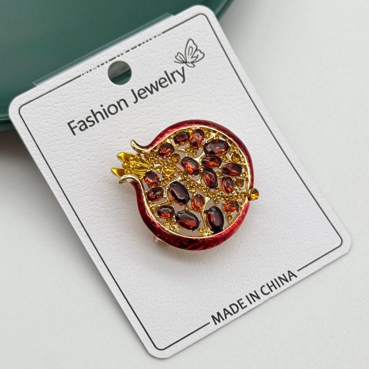 تصویر سنجاق سینه طلایی مدل انار با نگینهای کریستالی قرمز روی کارت بستهبندی Fashion Jewelry